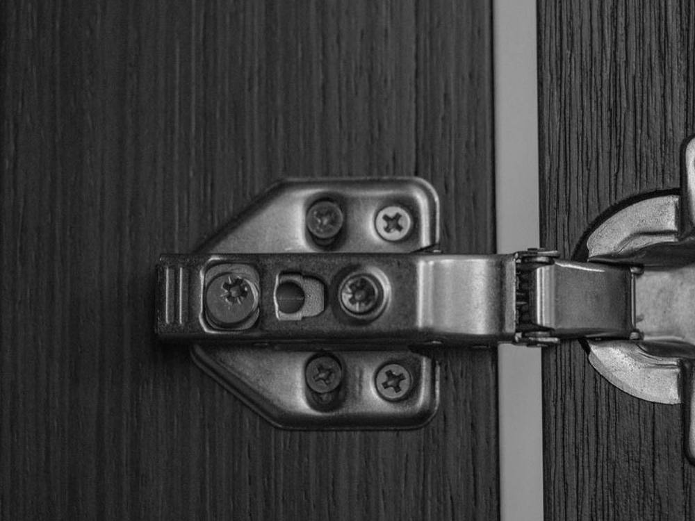 Concealed cup hinge fitted to a cabinet door